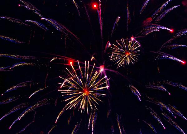 Colorati fuochi d'artificio illuminano il cielo notturno.